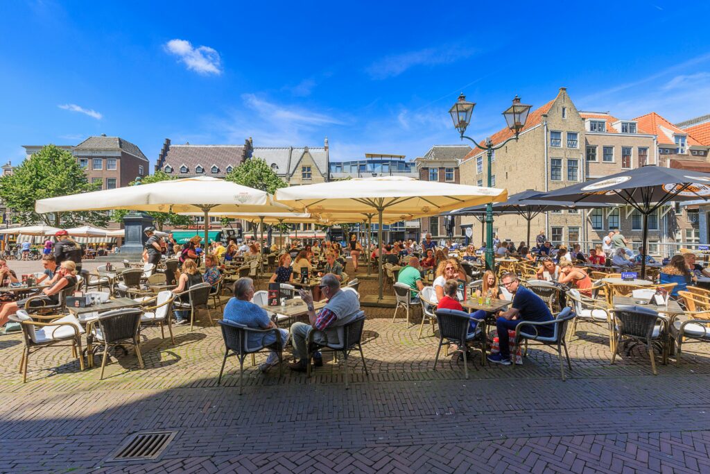 People enjoying a sunny day at an outdoor cafe in Dordrecht, Netherlands.